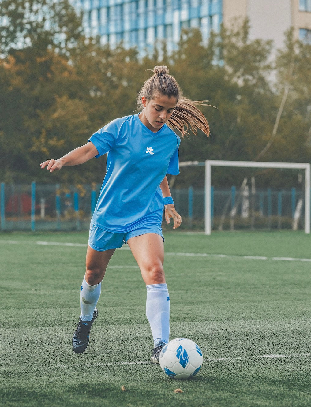 a young girl wearing blue football kits and white football socks